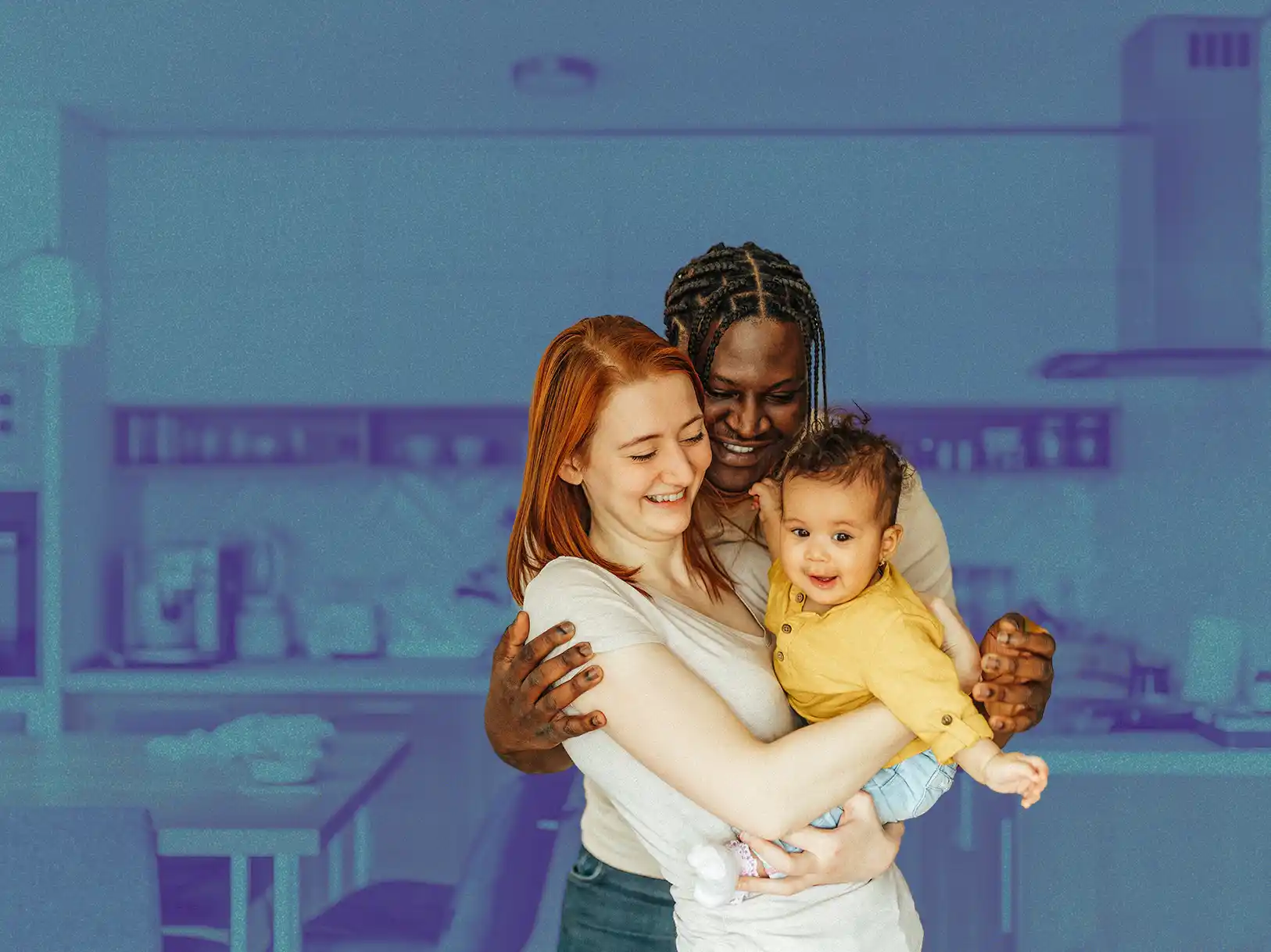 Mixed race couple holding their baby in their kitchen