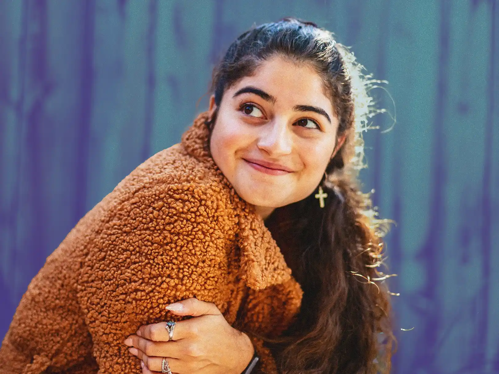 Young woman in a fuzzy sweater smiling because she's benefitting from prevention resources