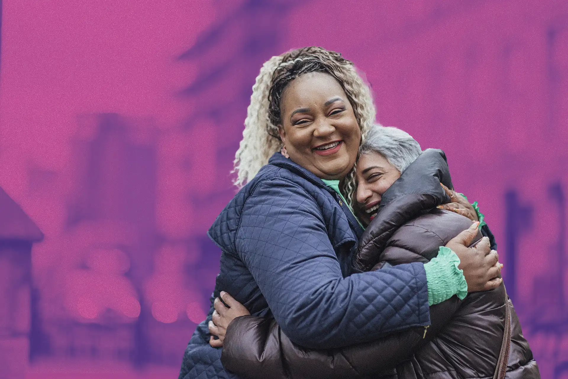 Two women smiling and hugging