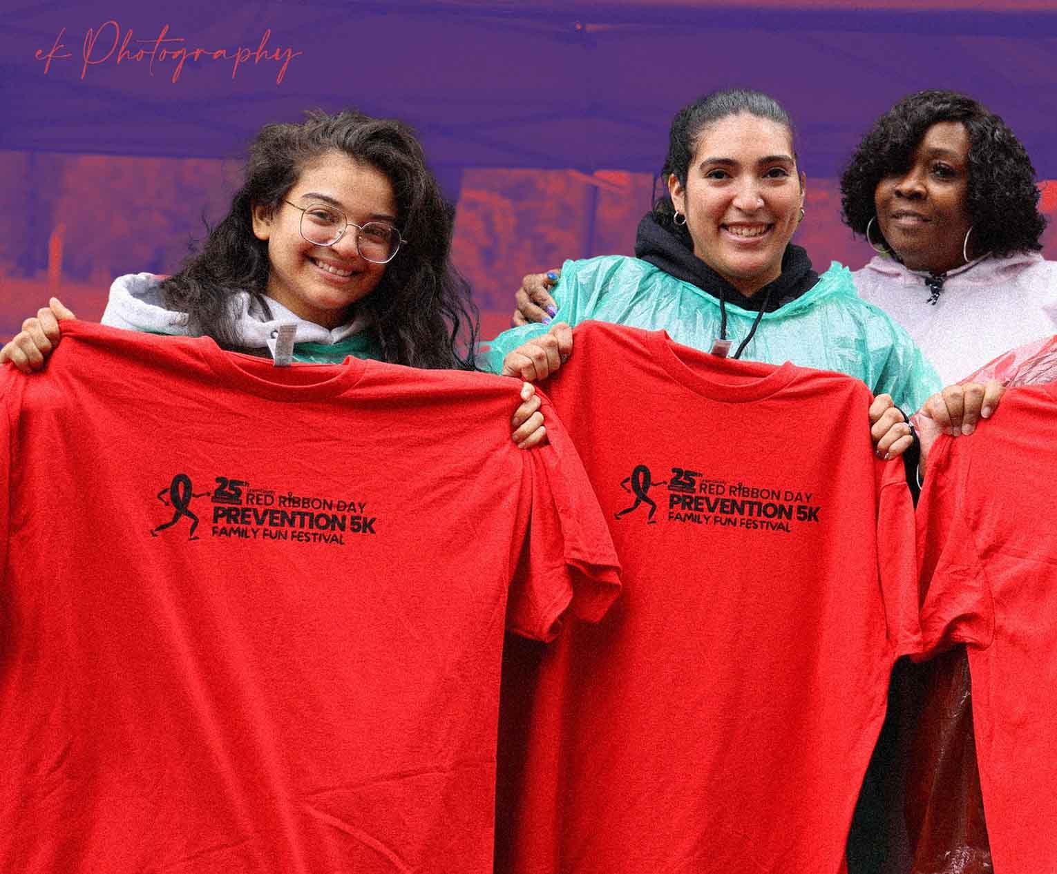 People at Red Ribbon Day holding up their free shirts