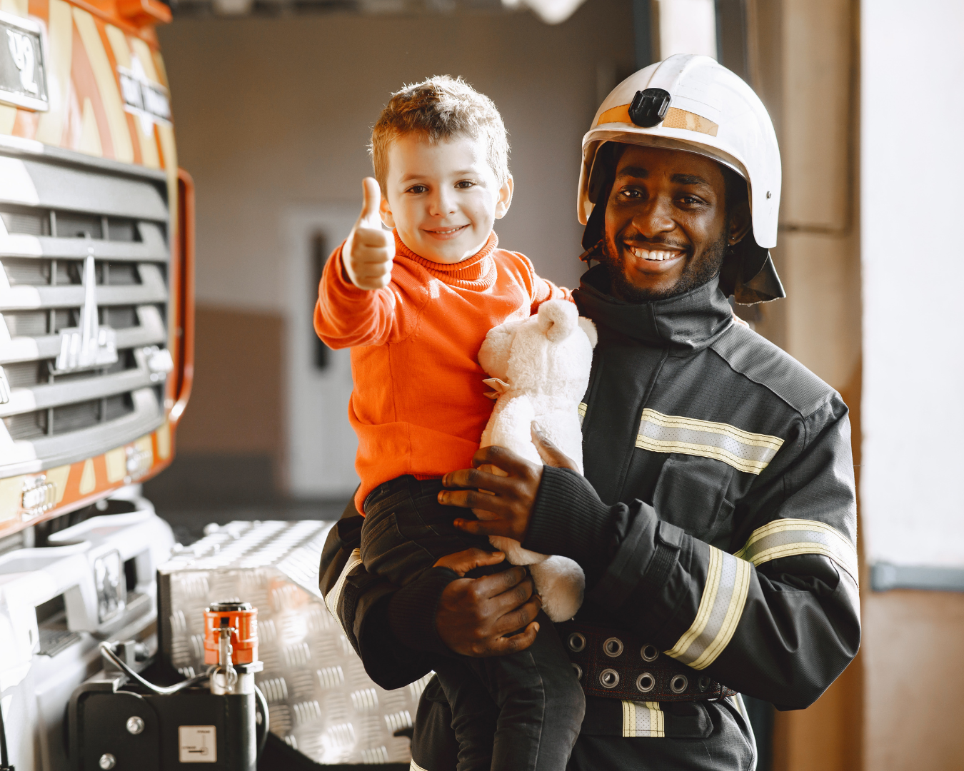 fireman holding child and smiling