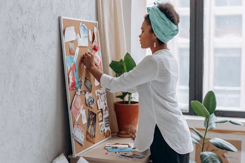 woman pinning items on a board